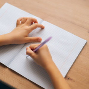 child writing ongrid paper